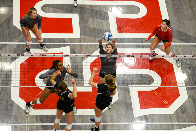 CSUN volleyball player hits the ball over the net