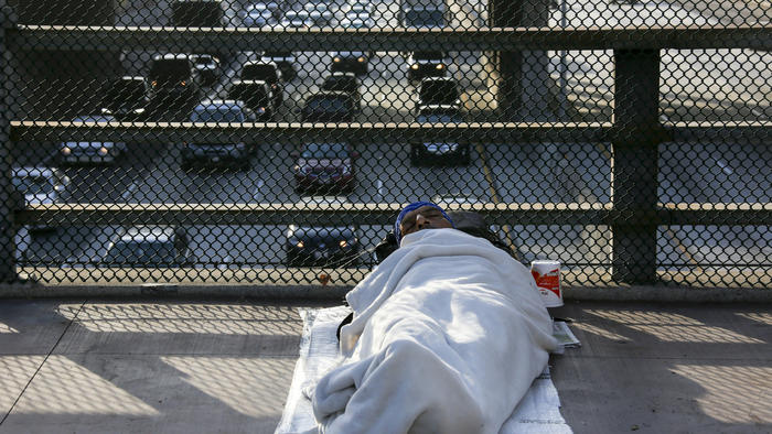 Homeless man sleeps on bridge