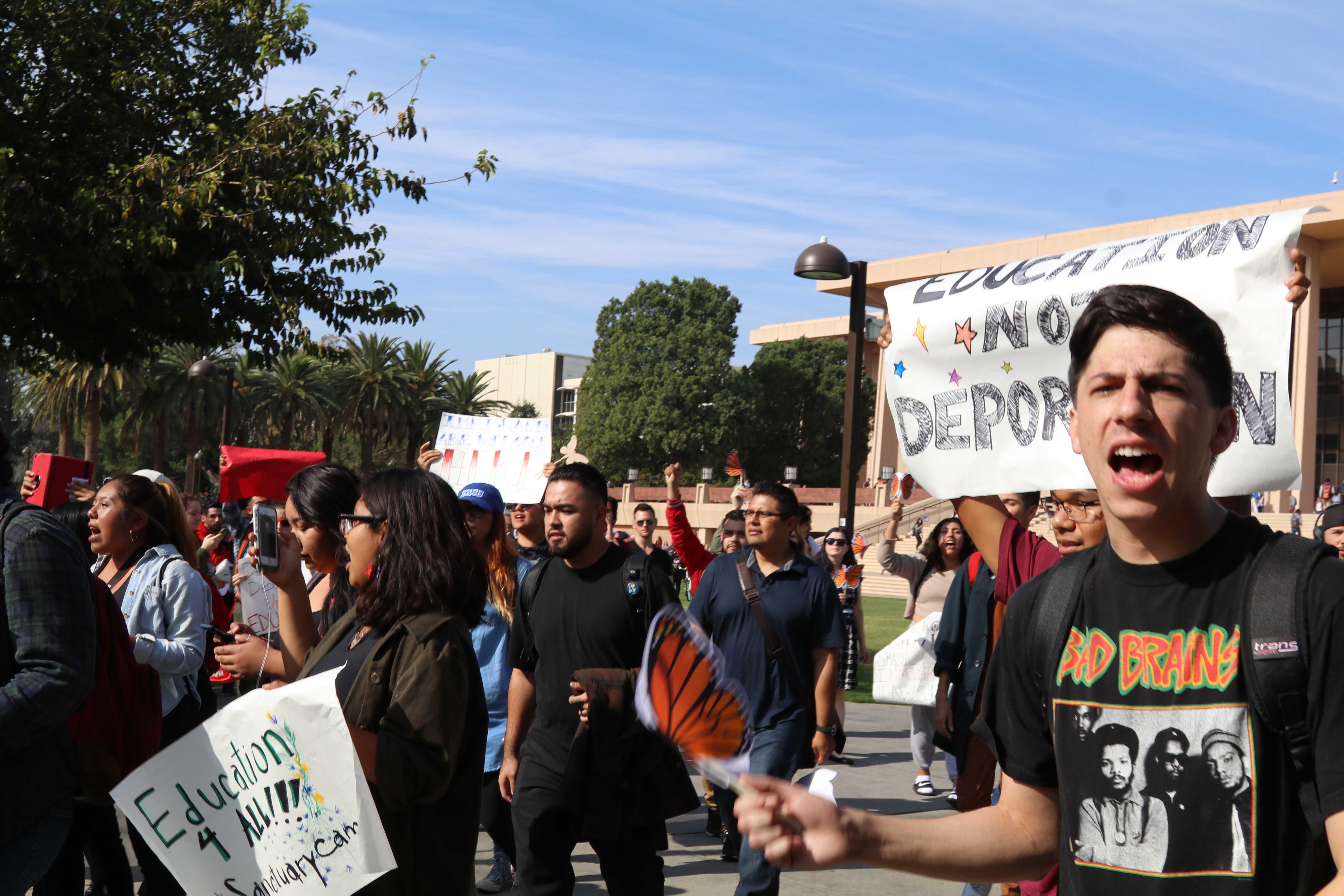 Protestors march in front of Oviatt Lawn around noon on Wednesday, calling for a safe campus for undocumented students. Photo credit: Blaise Scemama