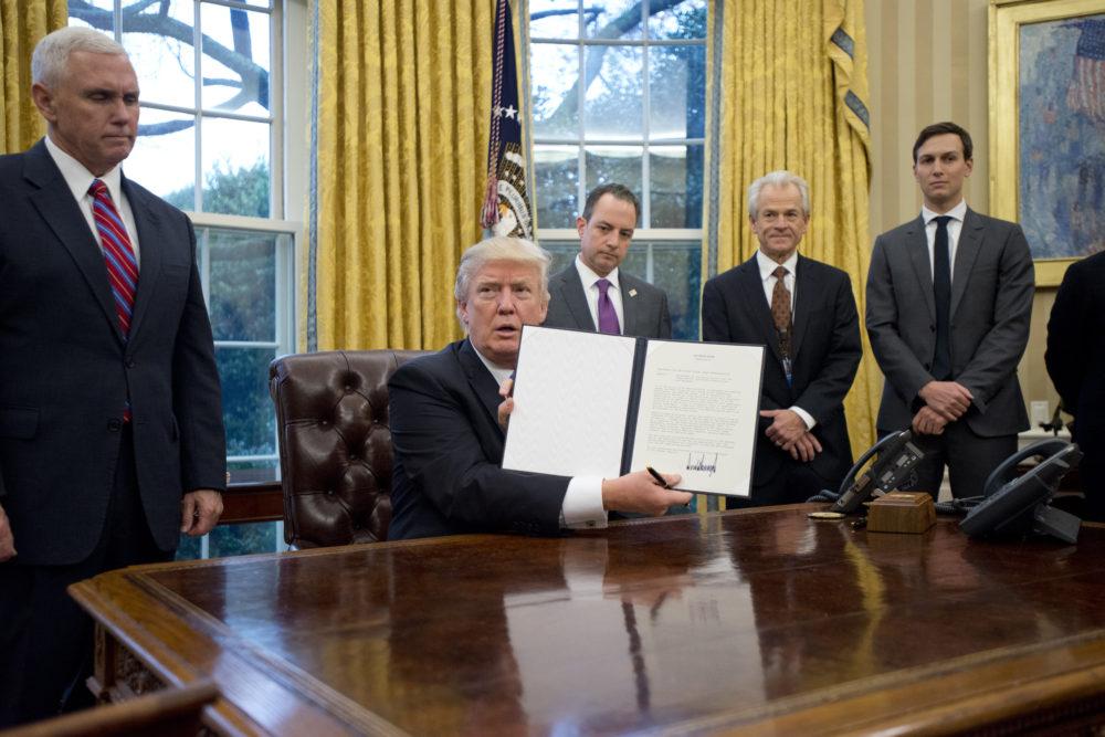 U.S. President Donald Trump shows the executive order withdrawing the U.S. from the Trans-Pacific Partnership after signing it on Monday, Jan. 23, 2017 in the Oval Office of the White House in Washington, D.C. Standing behind the him, from left, U.S. Vice President Mike Pence; White House Chief of Staff Reince Preibus; Peter Navarro, director of the National Trade Council; and Jared Kushner, senior advisor. Photo Credit, Ron Sachs/Pool via CNP/Abaca Press/TNS