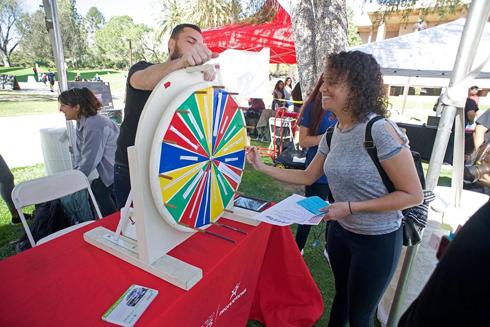 A member of the sustainability club plays a game with a csun student