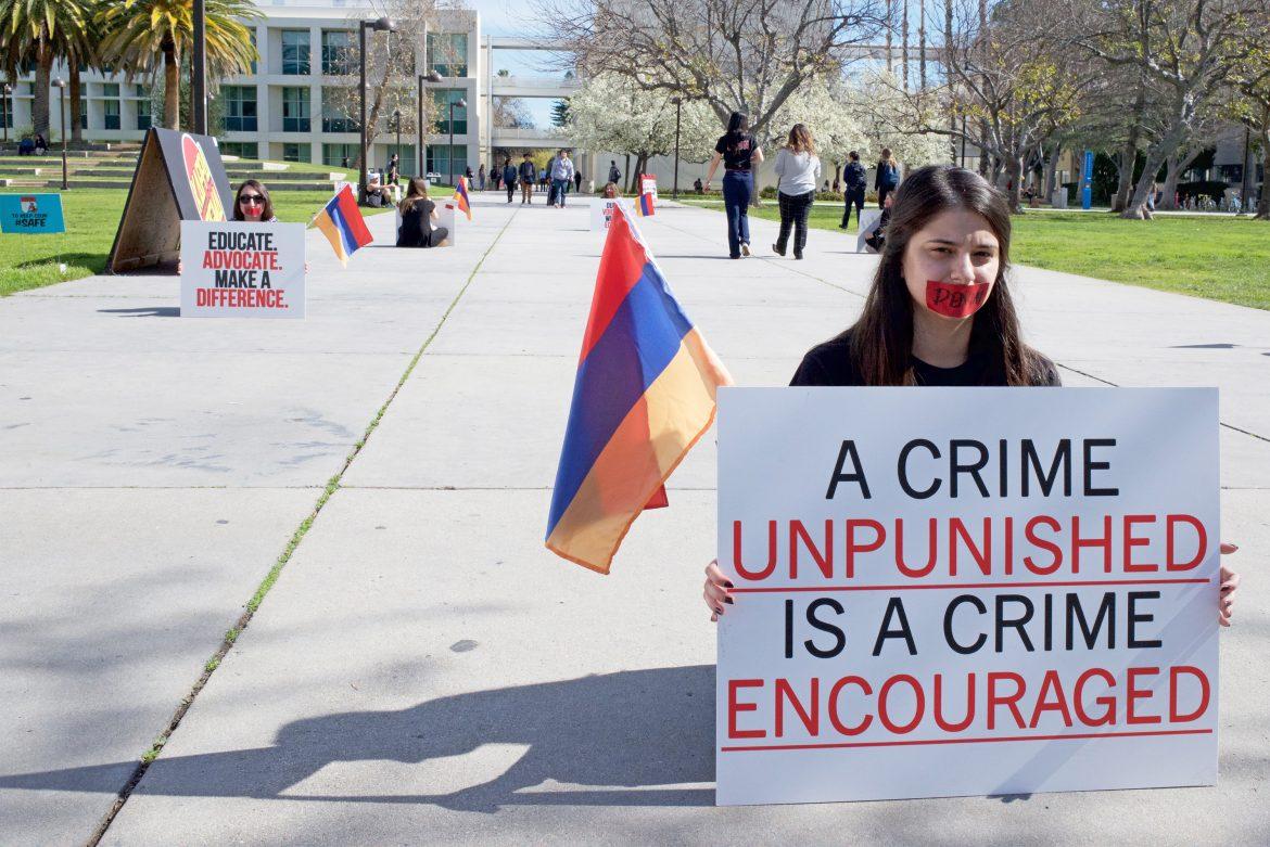 Student holds sign that reads,A crime unpunished is a crime encouraged