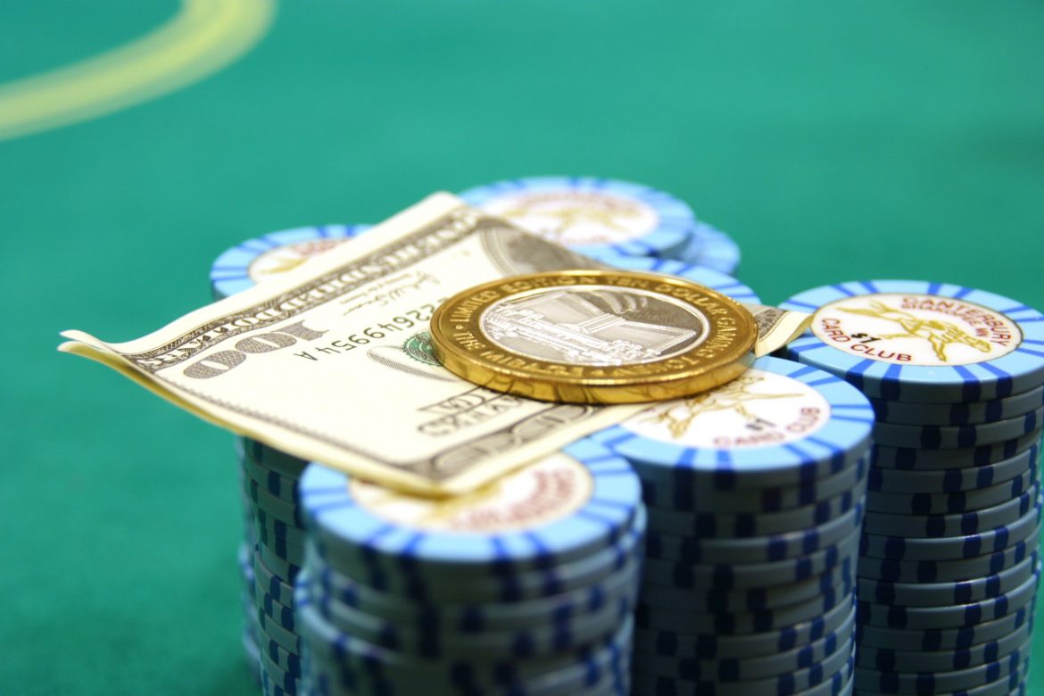 Poker chips are pictured with a 100-dollar bill