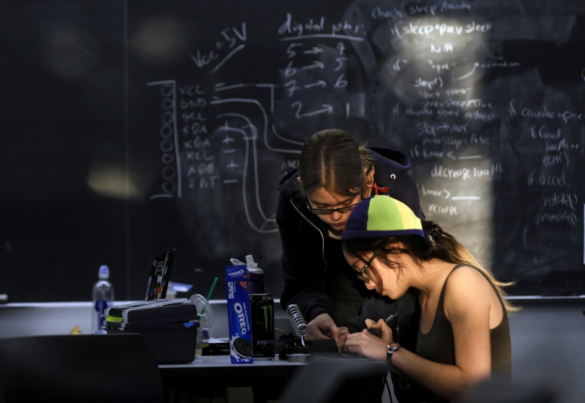 Morning sun hits Elizabeth Poss, 19, left, and Lauren Hu, 20, as they work on their group project 