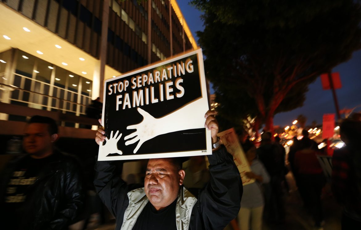 Man holds up a poster that says, stop separating families