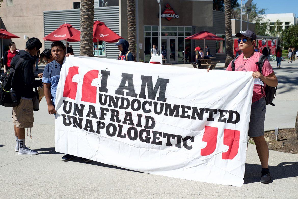 Students hold up poster that says, I am undocumented unafraid unapologetic
