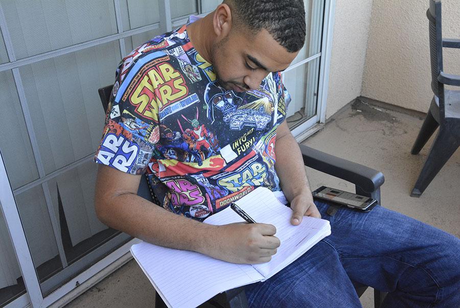 Brandon Hudson pictured writing in his notebook