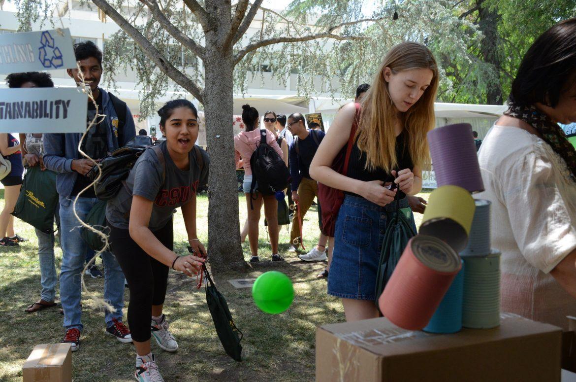Student Gayana Karade throws a ball in order to knock down the cans to win a prize at the Associated Students recycling booth during last year's Earth Day Fair that took place in front of Bayramian Hall on April 21. Photo credit: Erik Luna