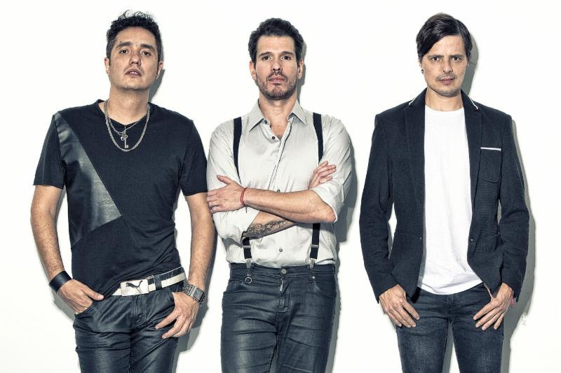 Mexican rock band members pictured, three men in their mid-thirties wearing matching navy blue and white oufits