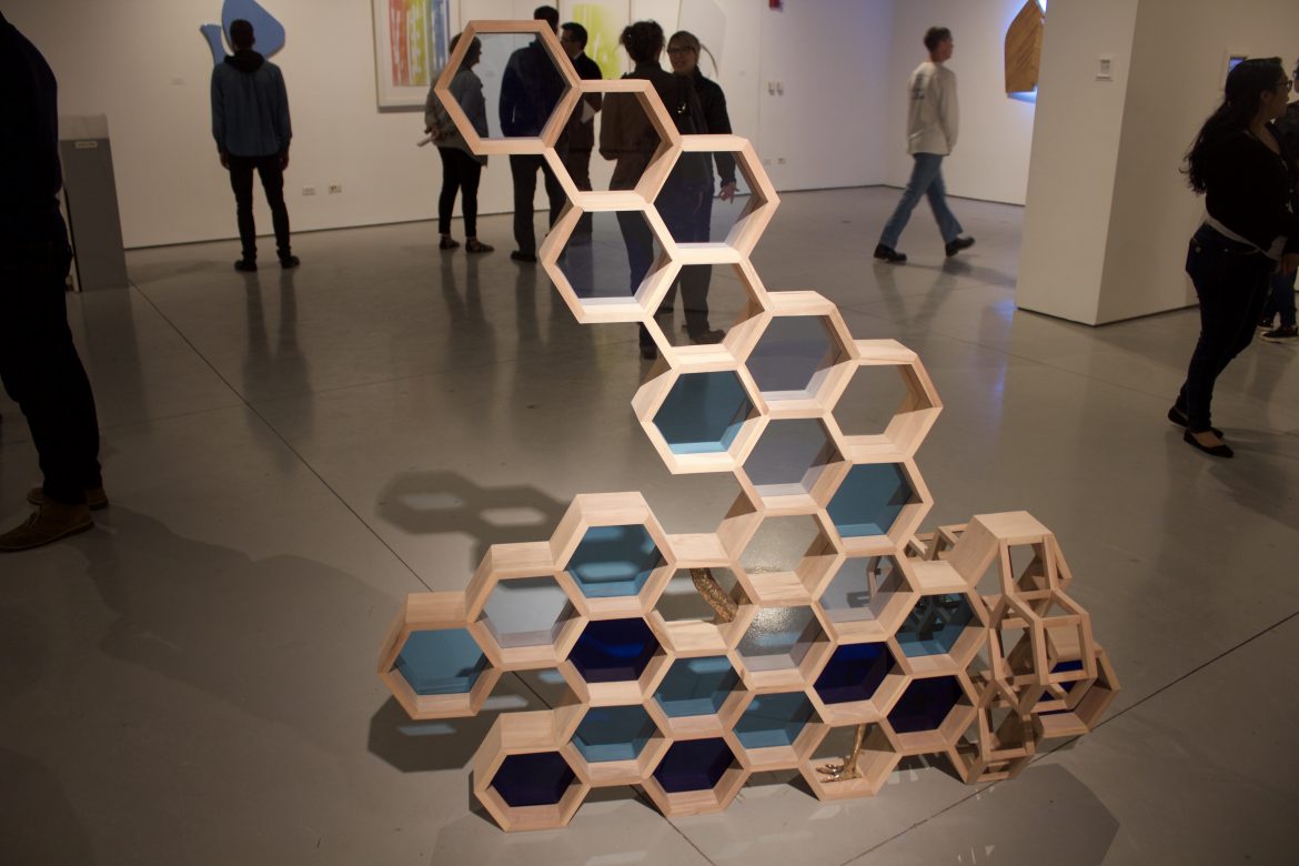 art piece shows connected hexagons with stained glass in the center