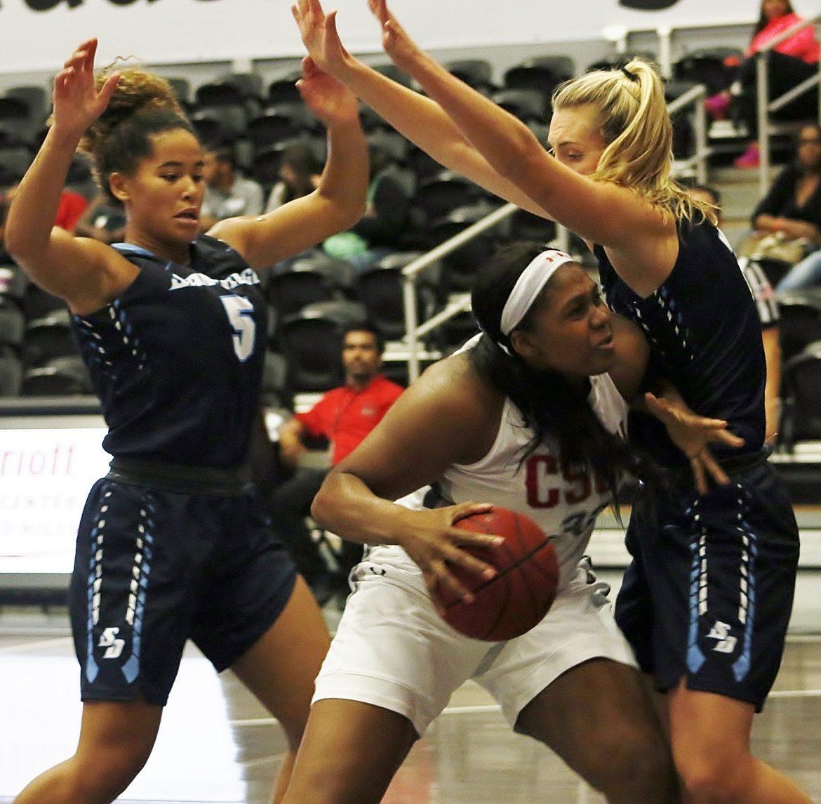 CSUN athlete tries to dribble her way towards the basket past the two girls blocking her