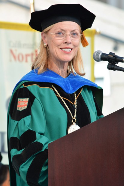 president Dianne F. Harrison wearing traditional teal blue and black graduation garment