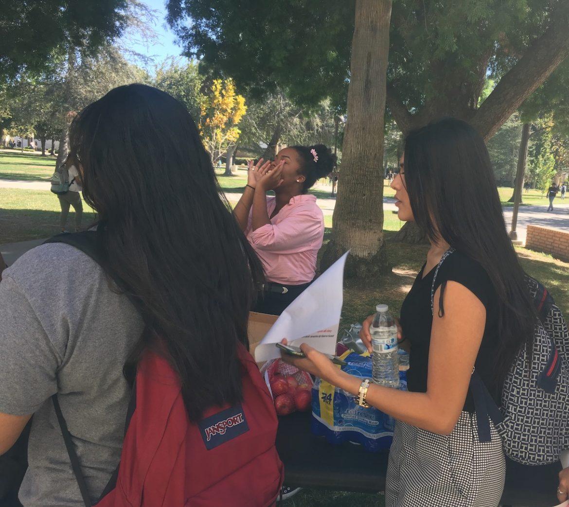 students in line for food in grass area