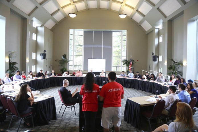 man and woman in red shirts standing in front of round table