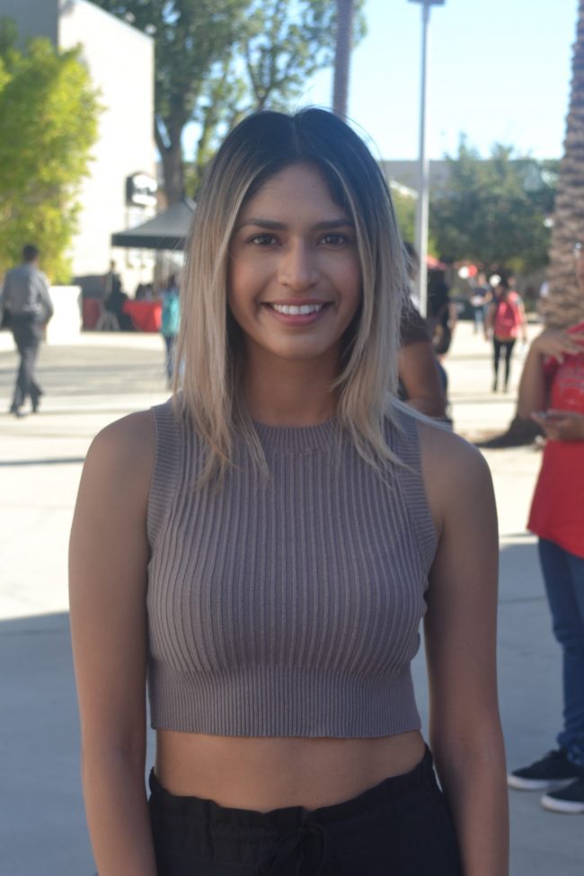 girl smiling with beige shirt and black pants