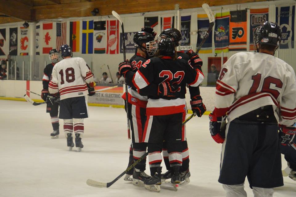 hockey players in black red and white huddled during game