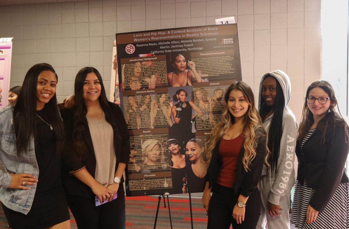 4 woman pose around poster