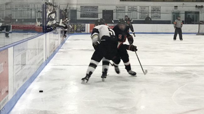 CSUN hockey player defends puck from opponent