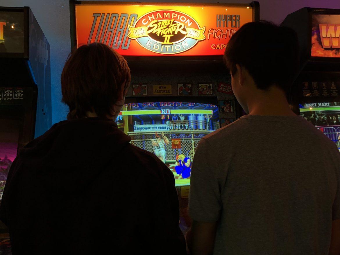 two students play an arcade game