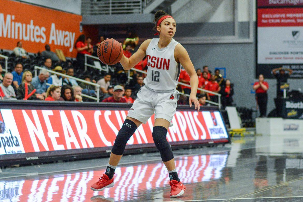 CSUN womans basketball player dribbles ball on the court