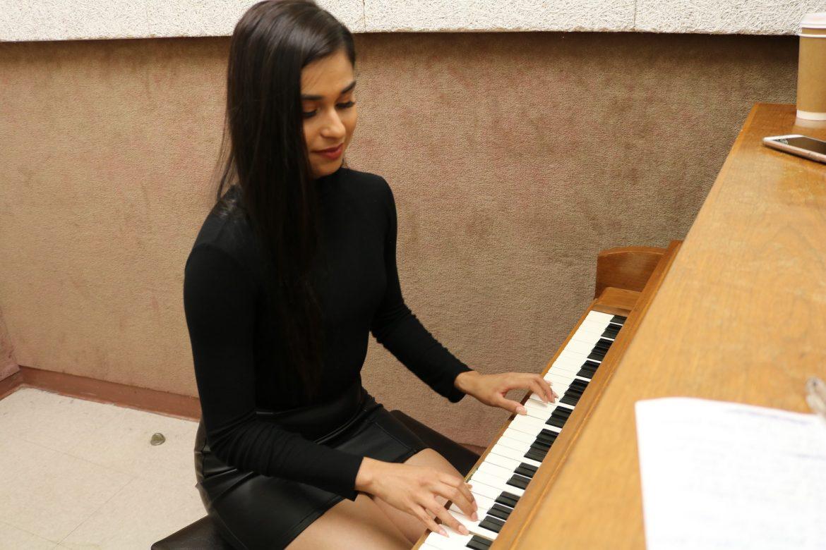 woman dressed in black plays piano