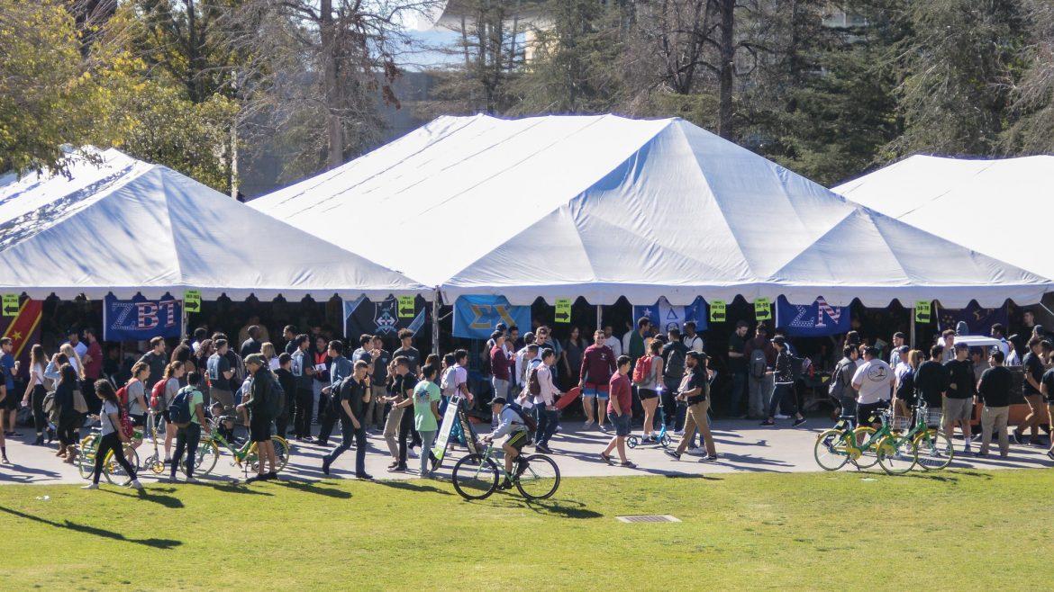 large white tents with many students surrounding them