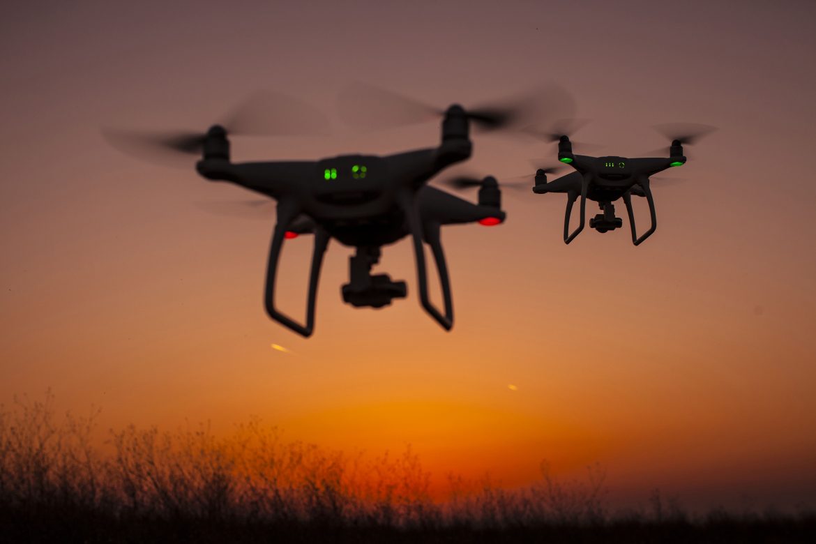 two+drones+flying+in+the+sunset