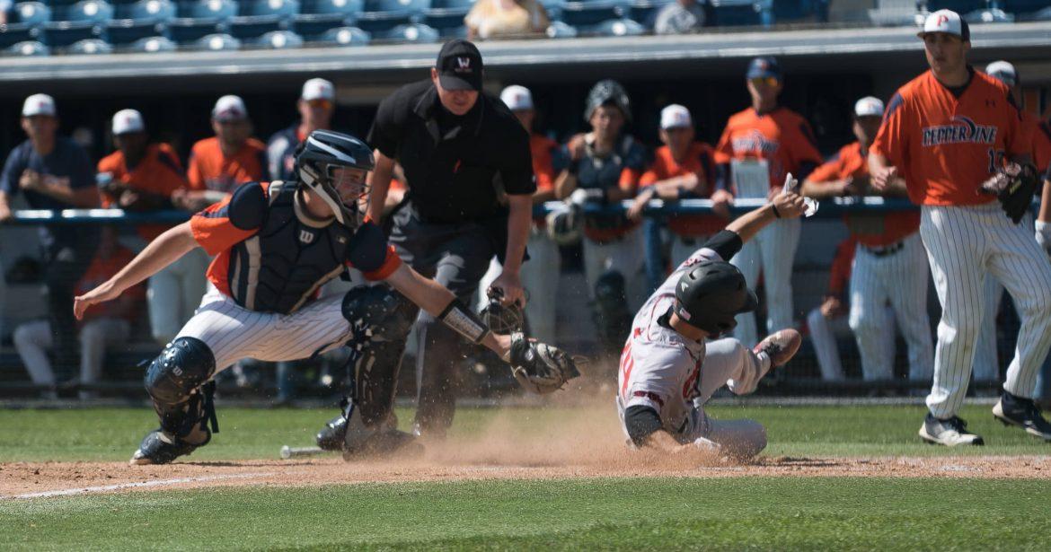CSUN baseball player in grey uniform slides to base while opponent tries to tag him out