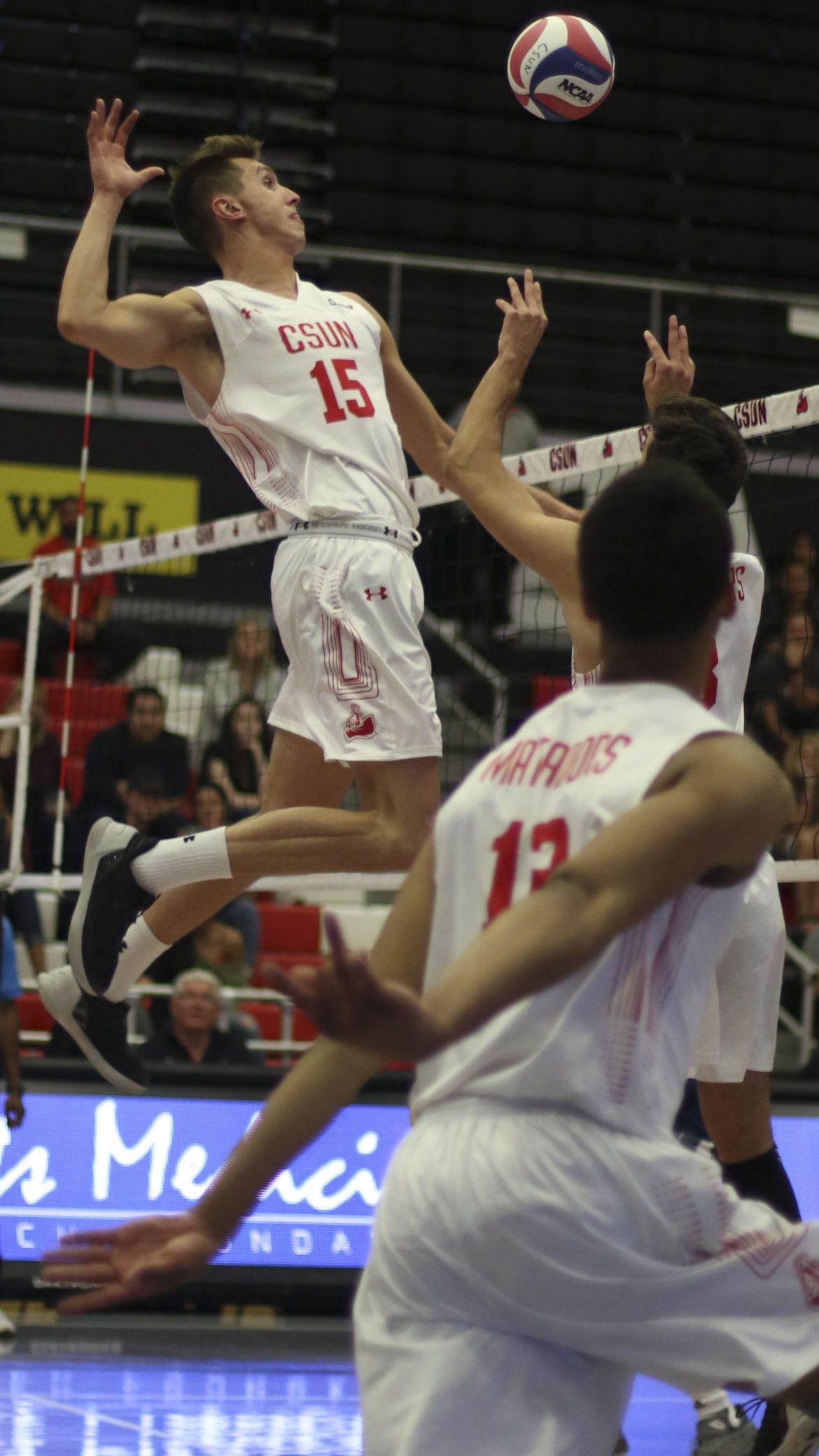 Eric Chance leaps above the net for a kill. Photo credit: Daniel Valencia