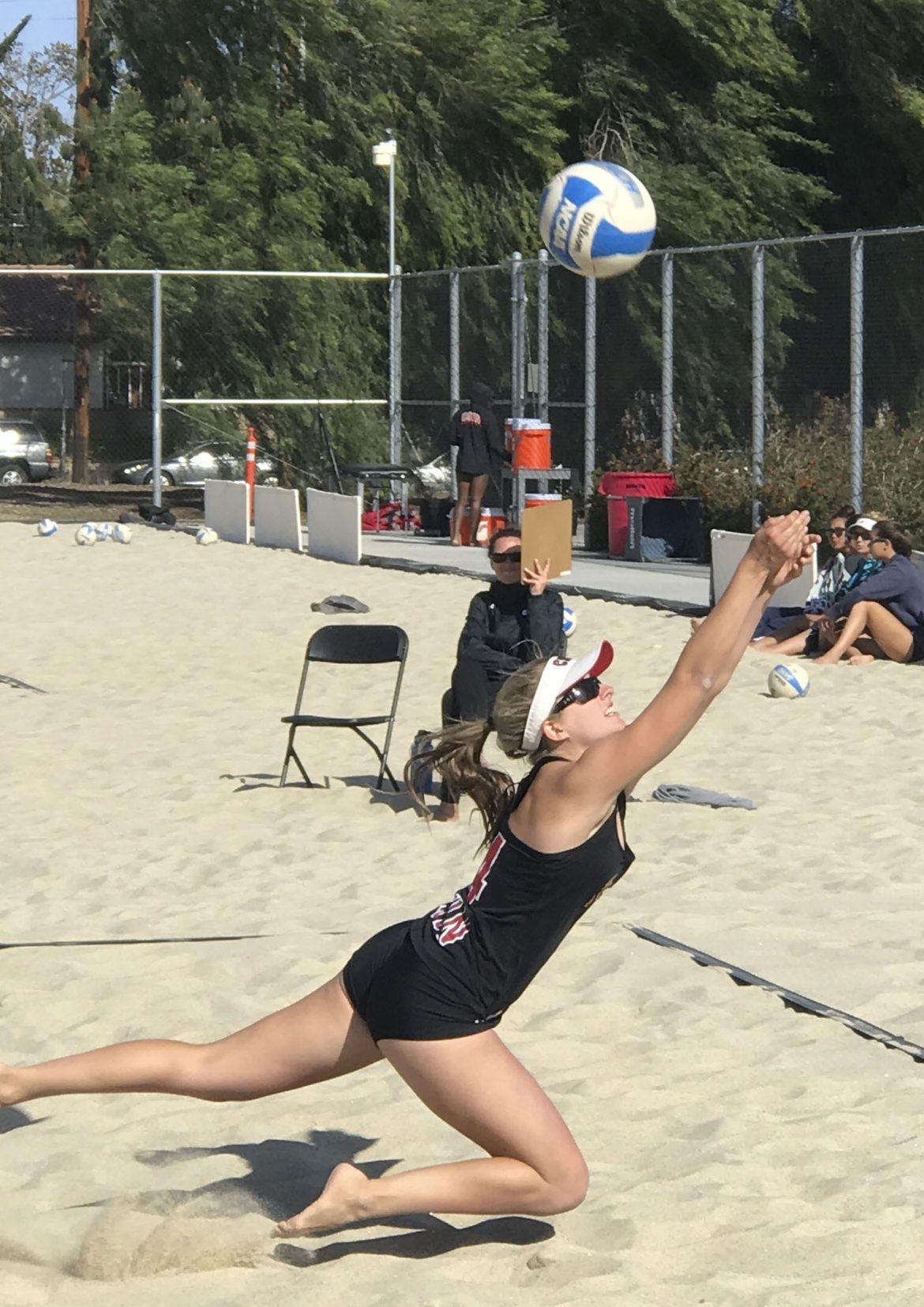 woman+hits+ball+up+into+the+air+during+sand+volleyball