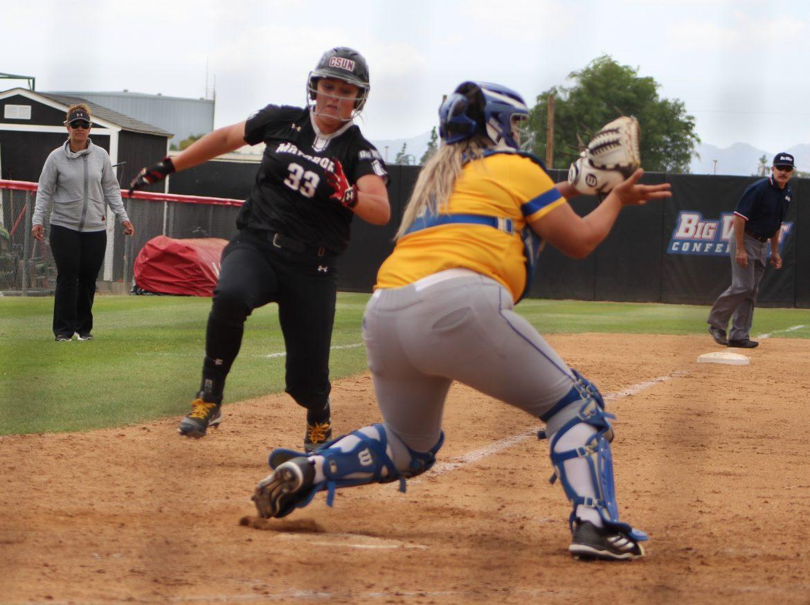 CSUN womans softball player dressed in black runs to base where opponent is waiting to catch the ball