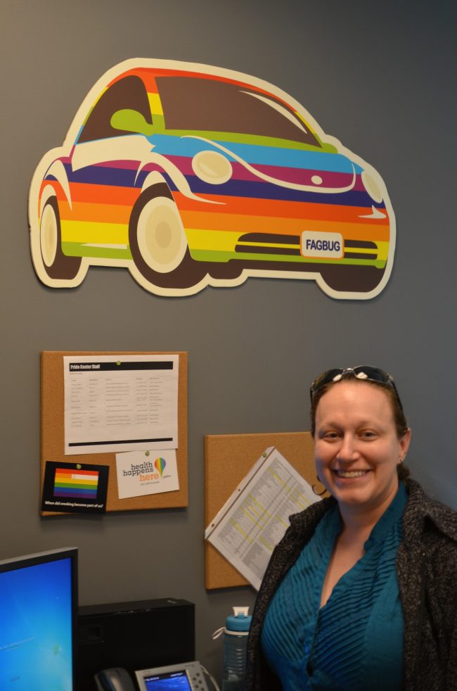 woman posing in office with rainbow colored car