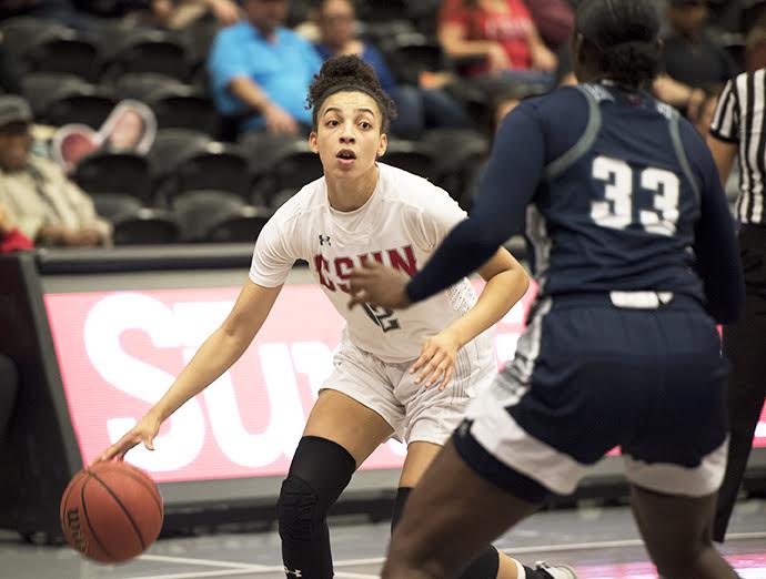 A CSUN Womens basketball player dribbling the ball on the court.