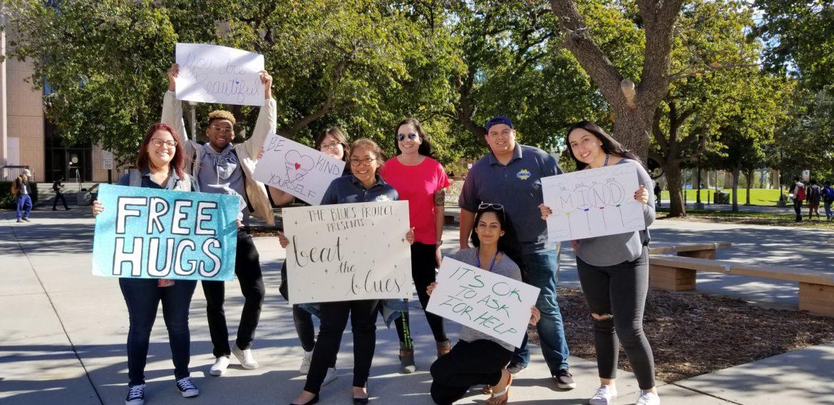 A group of CSUn students carrying Free hugs posters on campus