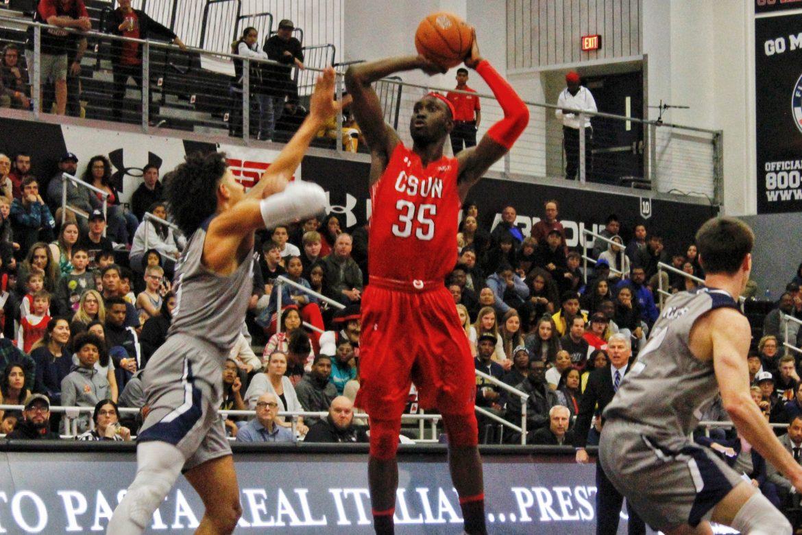 A CSUN Mens basketball player making jumpshot in front of a defender