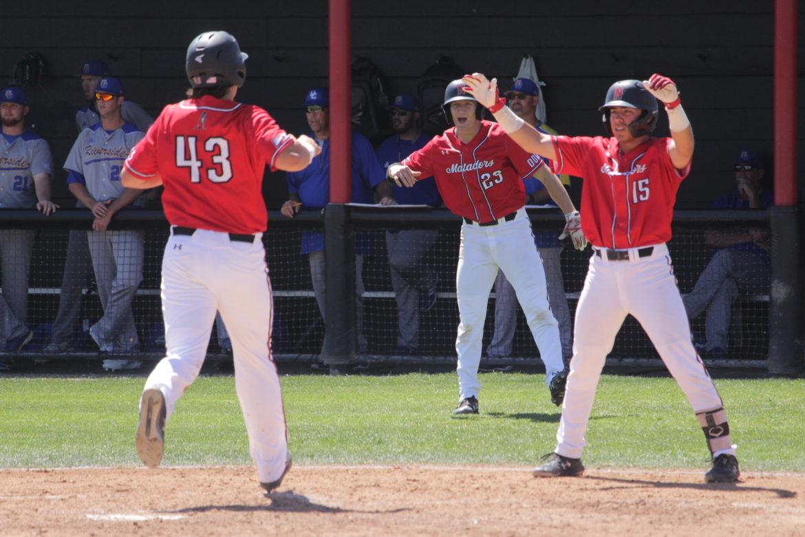 Andrew Lucas (23) and Jose Ruiz (15) cheer on Wesley Ghan-Gibson (43) as he crosses home plate in the third inning of Sunday's game against UC Riverside. The Matadors tied a school record for runs scored in a Big West series with 50 in the sweep over the Highlanders. Photo credit: Chelsea Hays