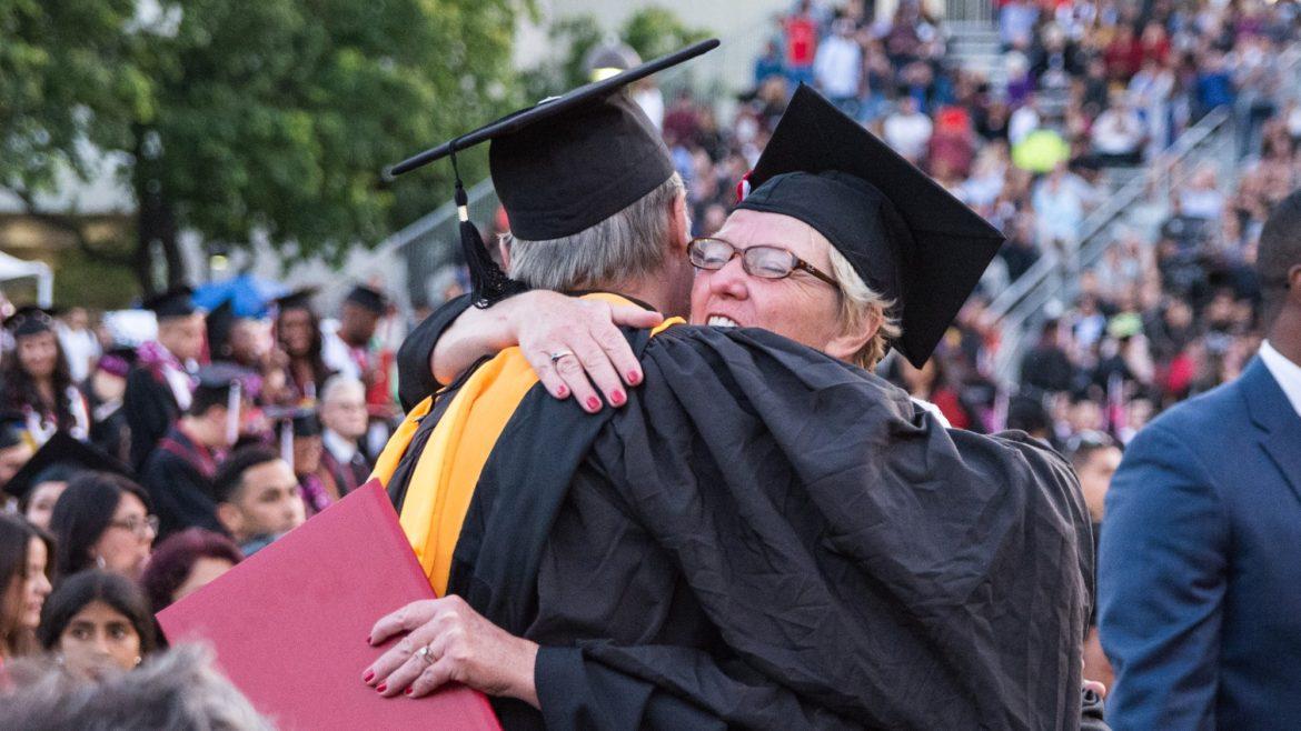 Graduating student embraces professor after receiving diploma at the Mike Curb College of Arts, Media, and Communication commencement ceremony of 2018. Photo credit: Joshua Pacheco