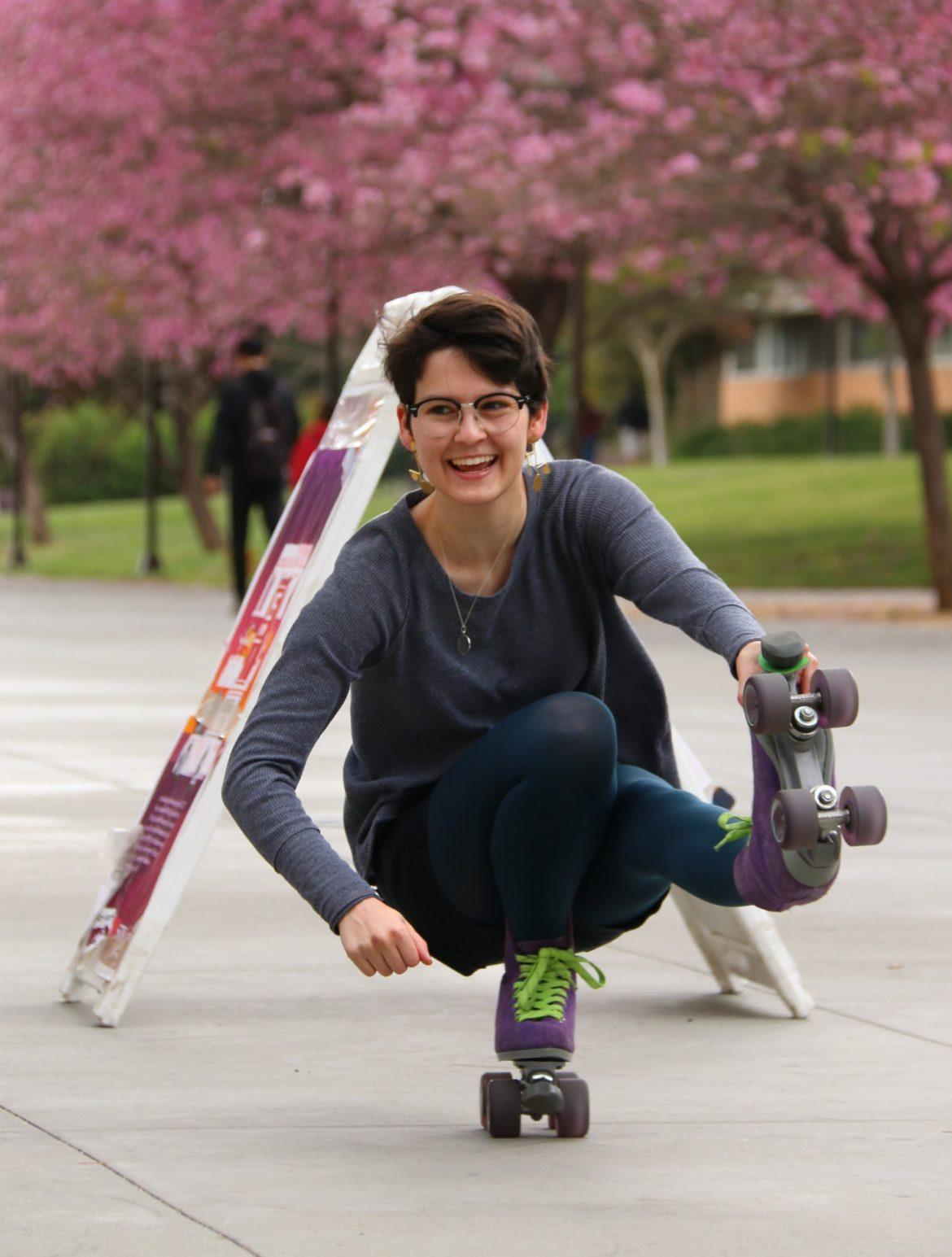 A female student roll with one roller skate
