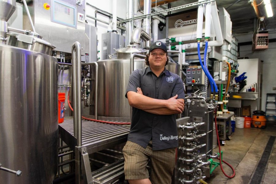 A+man+standing+in+front+of+a+brewing+machine