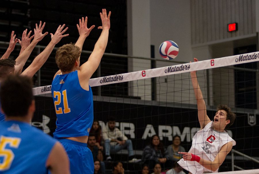 CSUN's outside hitter Griffin Walters (12) hits the ball towards a pack of UCLA Bruins on Feb. 28.