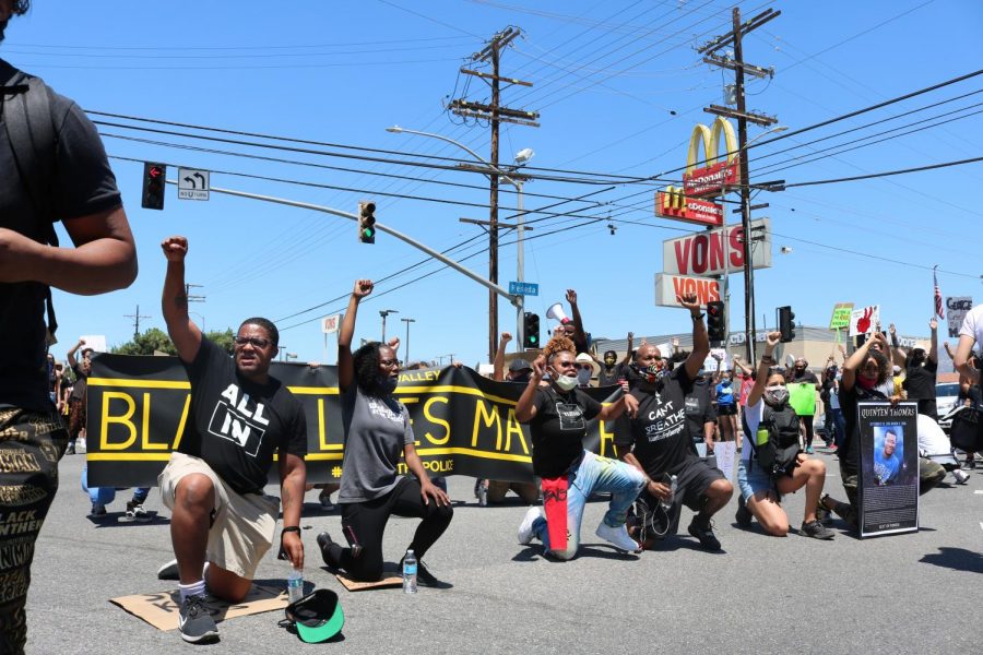 Organizers and protesters champion for change by kneeling in the intersection