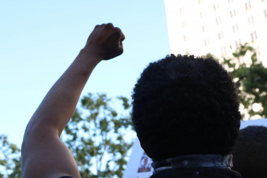 Black Lives Matter protester holds up his fist as protesters chanted Jackie Lacey must go in the background.