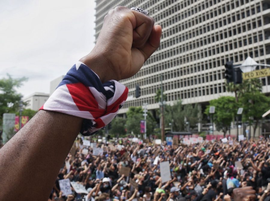 A protester holds up his fist as demonstrators hold a moment of silence for George Floyd outside of City Hall on May 31, 2020.