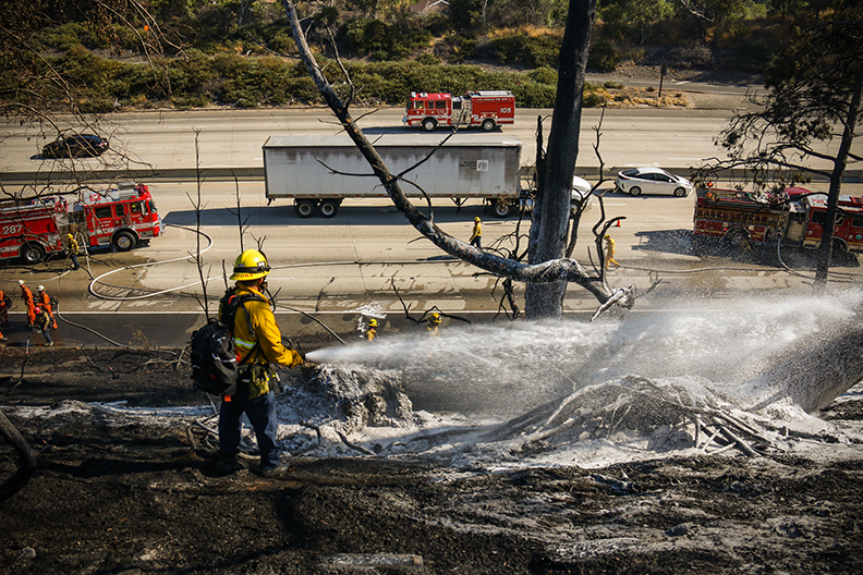 A LAFD firefighter sprays a chemical foam to prevent the fire from spreading further in Porter Ranch, Calif. on Saturday, Sept.4, 2020.