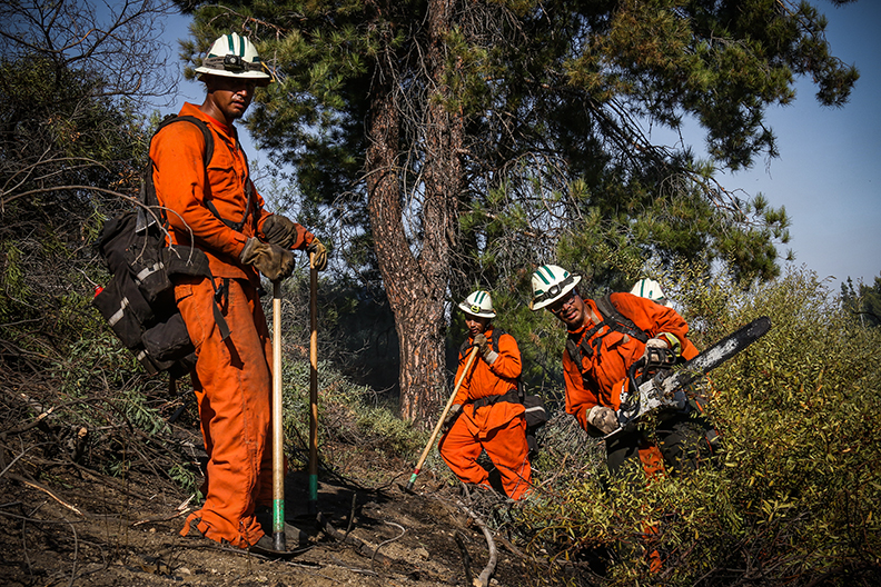 A group of inmate firefighters clear a line to prevent further fire spread during the Amigo Fire in Porter Ranch, Calif. on Sept. 5, 2020.