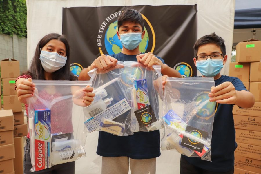 Sahara Karki, left, Nirvan Rayamajhi and Neil Rayamajhi hold up the hygiene kits for the homeless during their Bee The Hope packing event in Northridge, Calif., on Saturday, Sept. 12, 2020.
