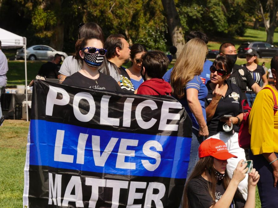 A woman holds up a Police lives matter flag at a rally for police officers in Elysian Park on Saturday, Oct. 17, 2020.
