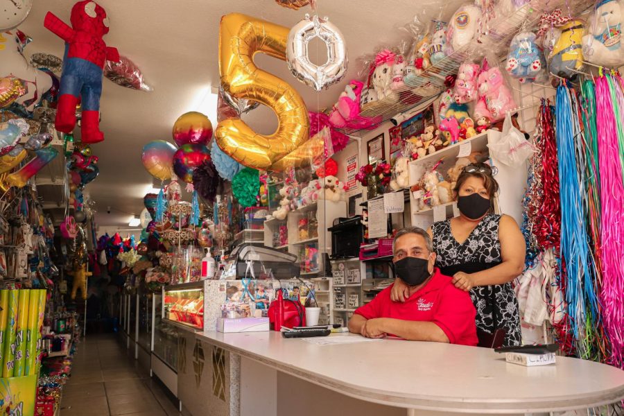 Claudia Paulino and Aurelio Rubio, the owners of Claudia's Party Store, sit at the cashier counter with their masks on in the store at Reseda, Calif., on Monday, Sept. 21, 2020.