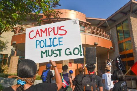 A woman holds a sign that says, Campus police must go, during the Cops off campus protest organized by ACP-CSU on Thursday, Oct. 1, 2020.