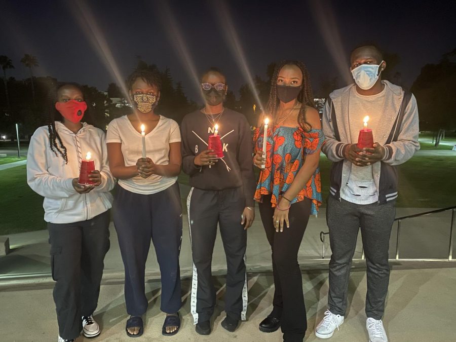 Florence Nalukwago, left, Jean Tusubira, Rebecca Nammudu, Gift Udeh, and Joel Kavuma stand atop the steps of the Oviatt Library to bring awareness to humanitarian crises throughout Africa.